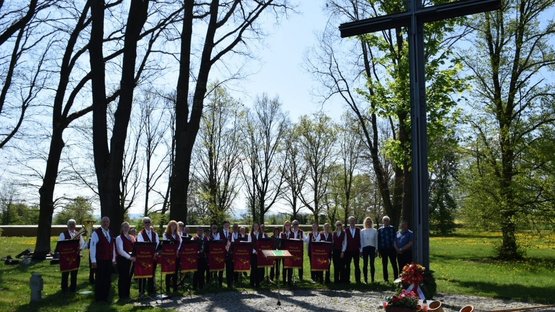 Gruppenfoto einer Musikkapelle am Hochkreuz einer Kriegsgräberstätte