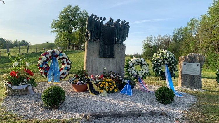 Gedenkstein mit Figurengruppe sowie Kränze und Blumenschalen: Am Tag genau vor 80 Jahren wurden die Überlebenden des Todesmarsches des Konzentrationslagers Dachau durch japanischstämmige Soldaten des 522nd Field Artillery Battaillon, den Nisei, befreit. Eine Geschichts- und Erinnerungstafel zum Todesmarsch als auch ein Denkmal für die Nisei wurden im Rahmen eines Gedenkaktes übergeben.  
