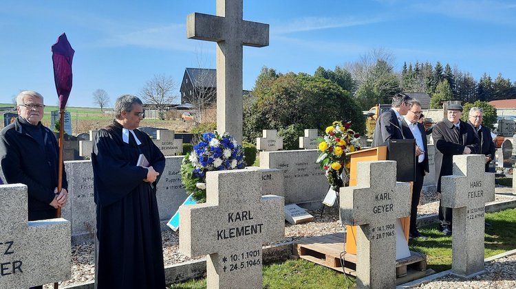 Menschen auf einem Friedhof, Grakreuze im Vordergrund: Die restaurierte Kriegsgräberstätte Kirchenlamitz wurde wieder eingeweiht.