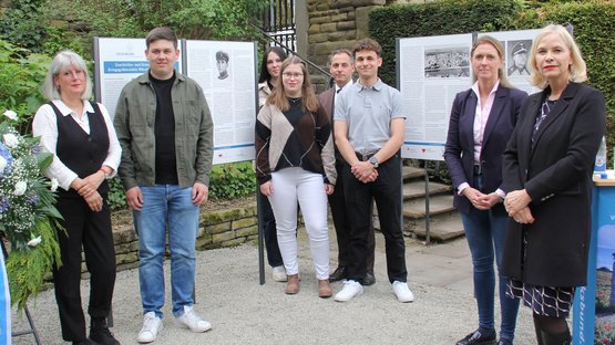 Personengruppe vor und neben einigen Schautafeln. Die Übergabe der Geschichts- und Erinnerungstafeln auf der Kriegsgräberstätte Würzburg - Hauptfriedhof