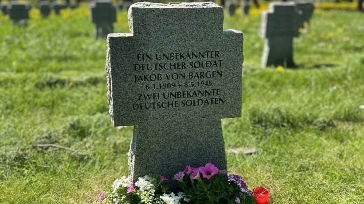 Steinkreuz auf einer grüen Wiese: Das Grab von Jakob von Bargen auf der Kriegsgräberstätte Cheb/Eger.